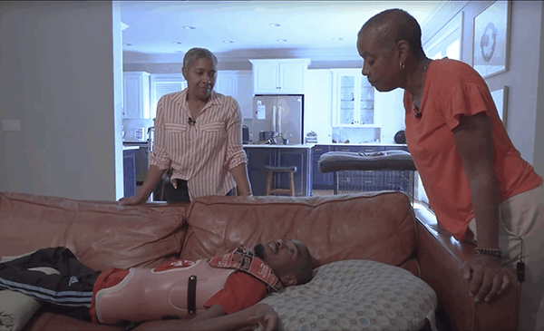 Photo of Ann W. Jackson interviewing Brandon and his mother, Tracy, in their home.